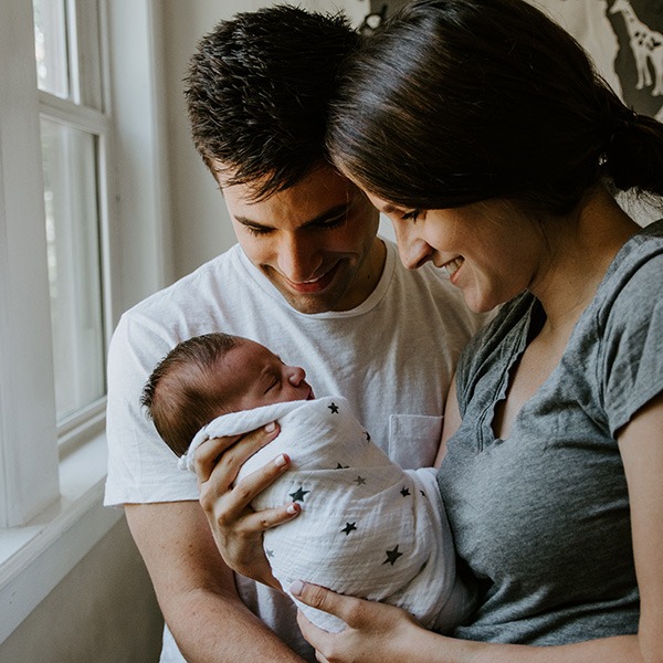 Mother and father hold and looking at newborn