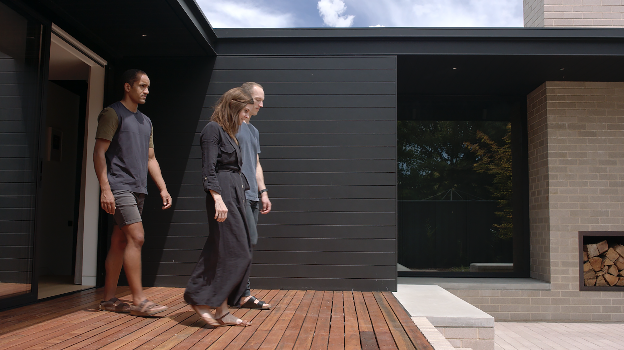 male clients and female architect walking on outside desk