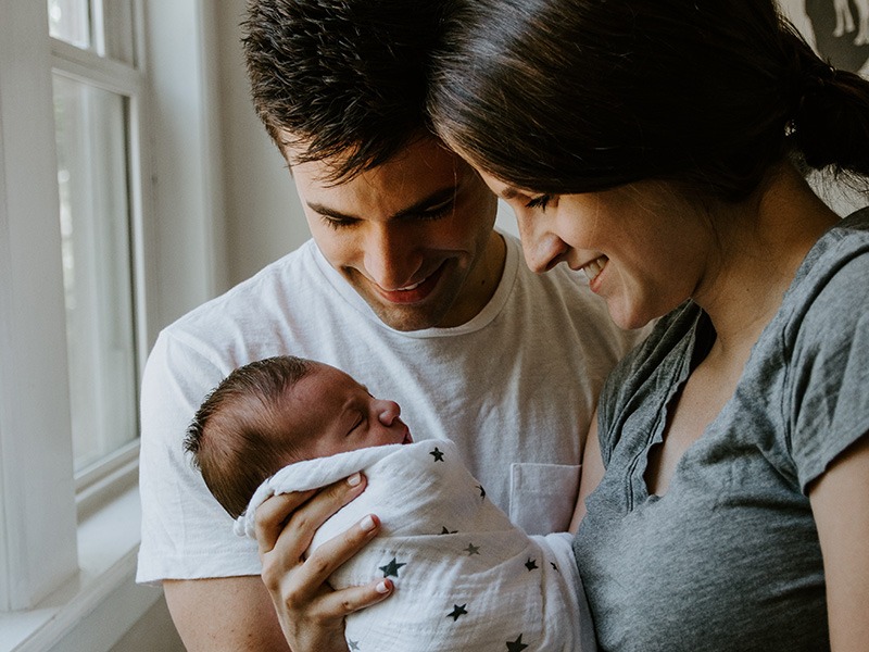 Mother and father hold and looking at newborn