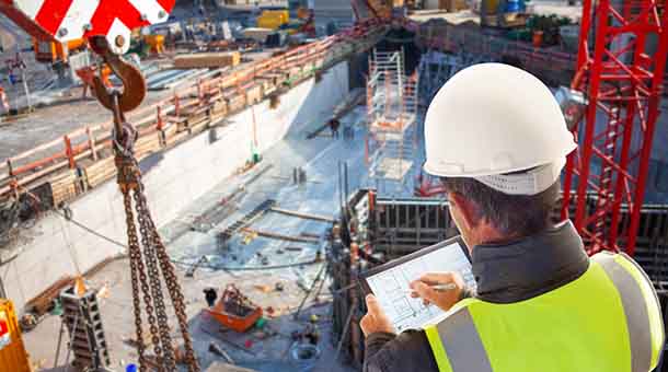 man overlooking construction site using tablet