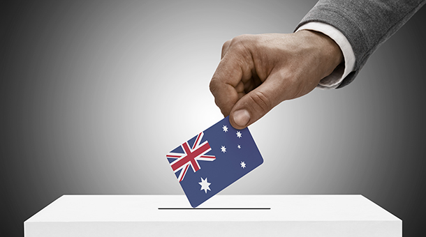 hand placing australia ballot card in vote box